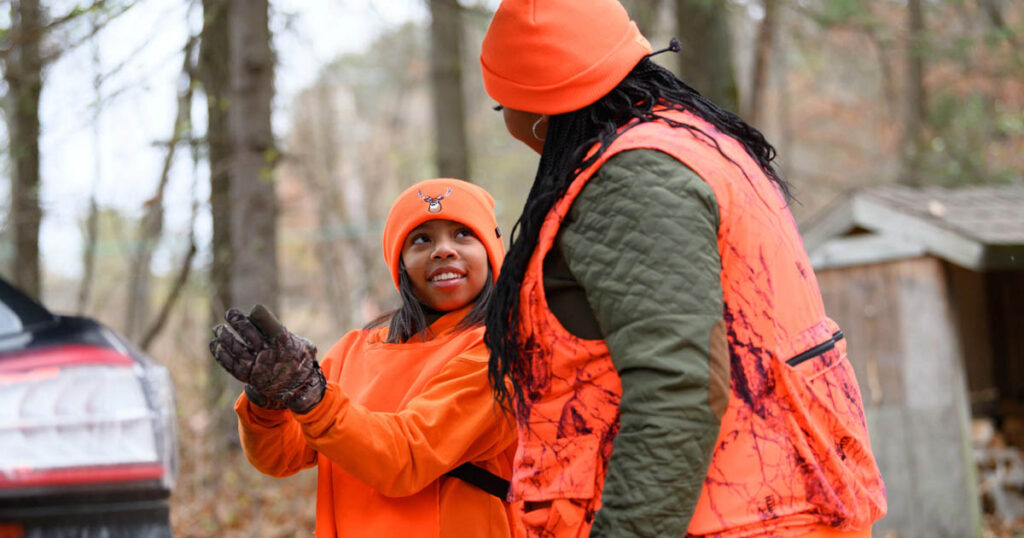 black woman and young black girl in blaze orange hunting